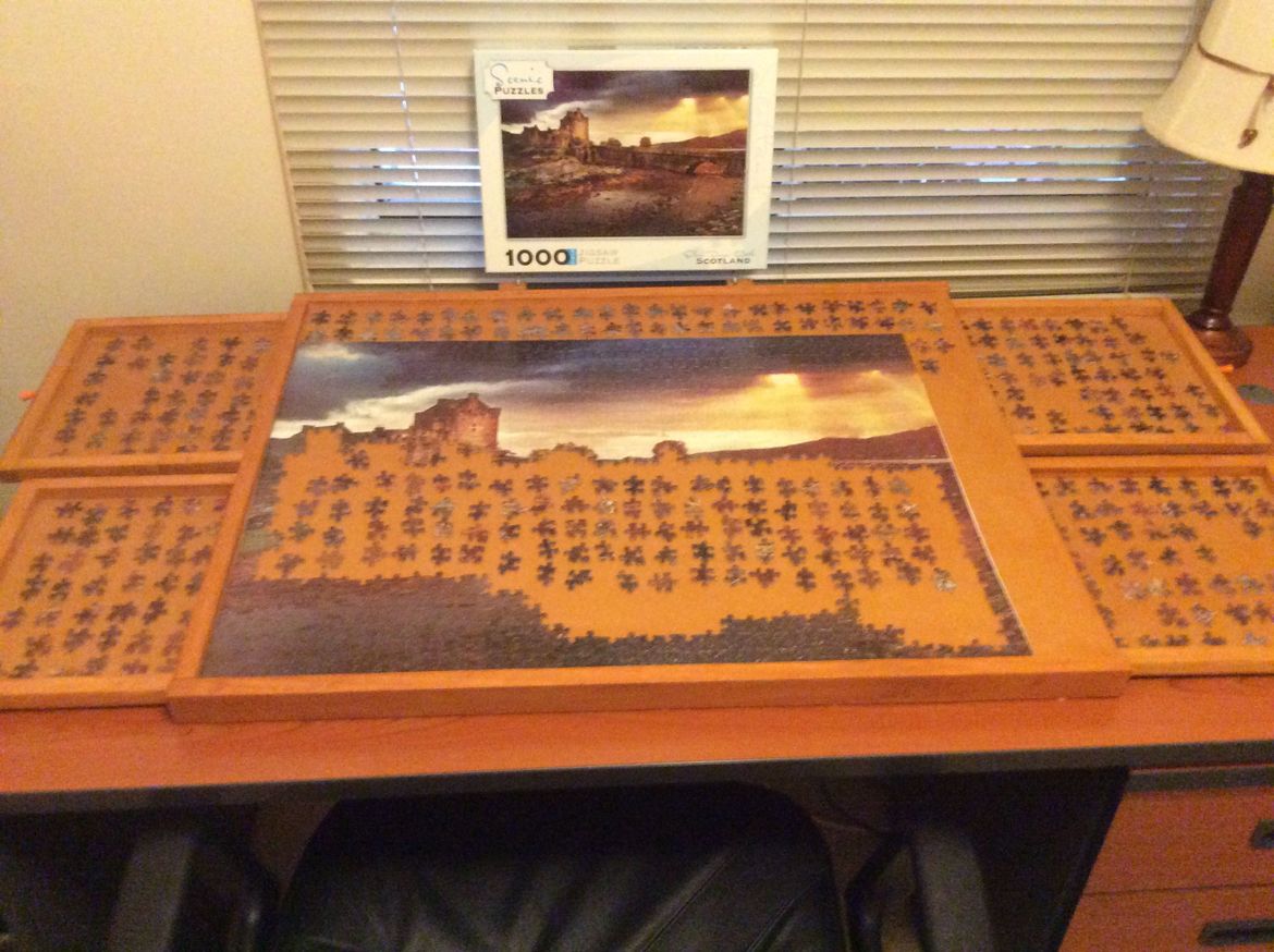 Jigsaw puzzle table with drawers to hold loose pieces of puzzles. Table tilts upwards to ease stretching.