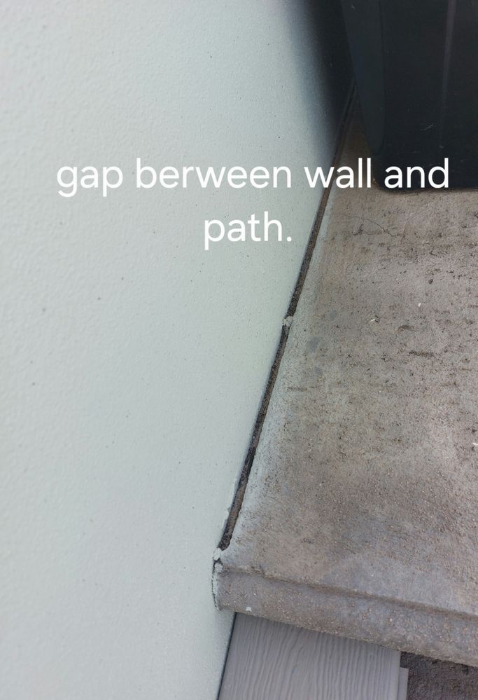 gap has tape between wall and path on both house and fence side.