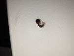 Drill hole with edge of metal plate, between brick and plaster