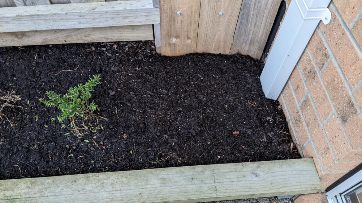 A small garden bed with one side touching the outer brickwall