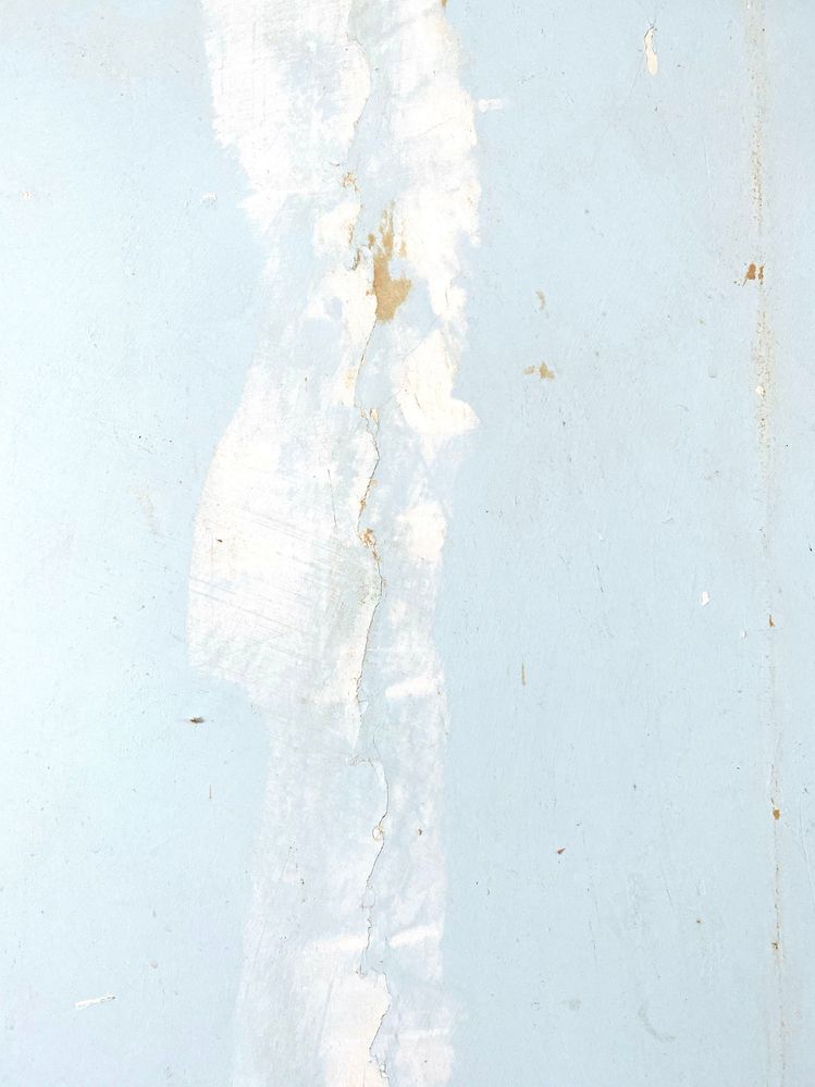 poorly patched cracks and wallpaper backing residue