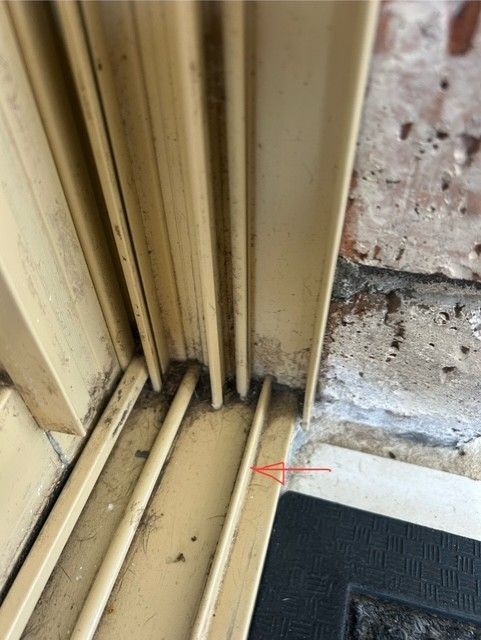 Arrow showing bottom track where new screen door will sit.