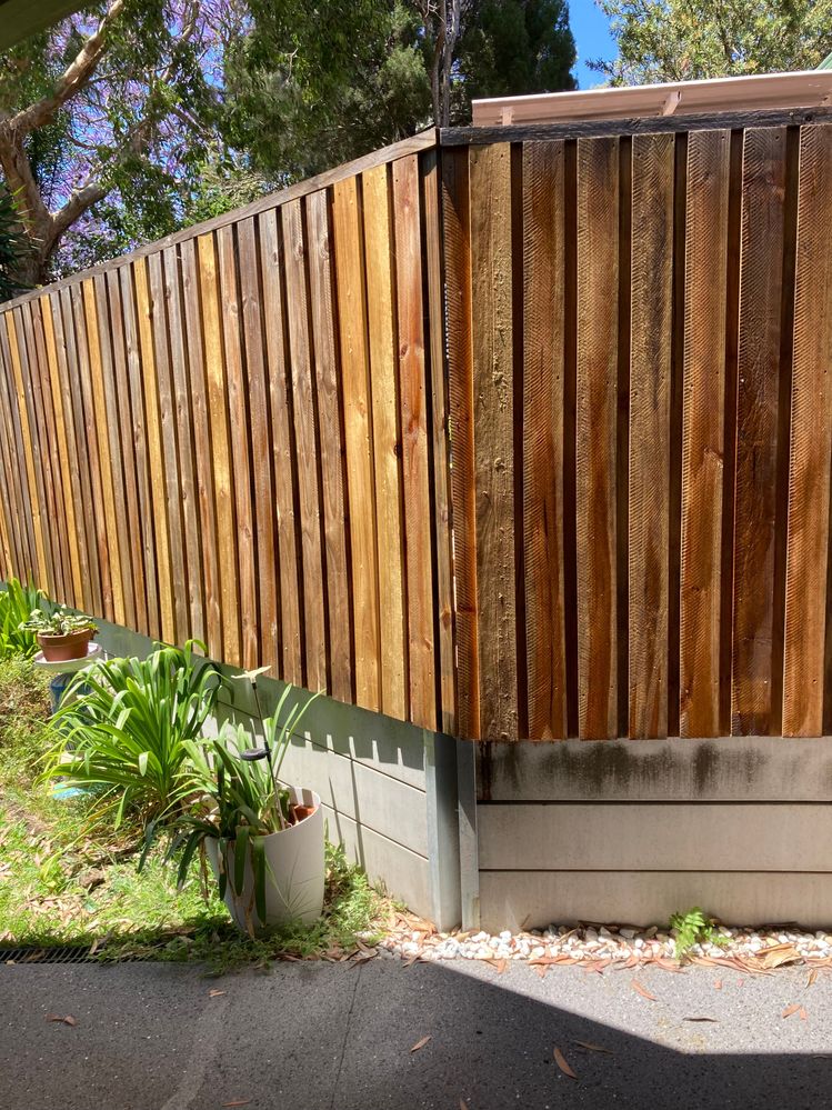 Partly varnished back timber fence.