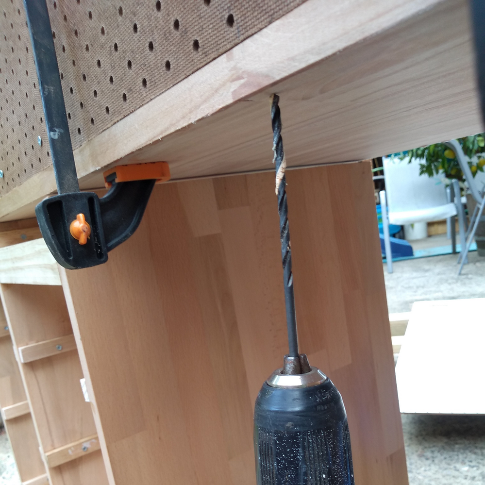 8.9 Drilling attachment holes from beneath bench into pegboard..png
