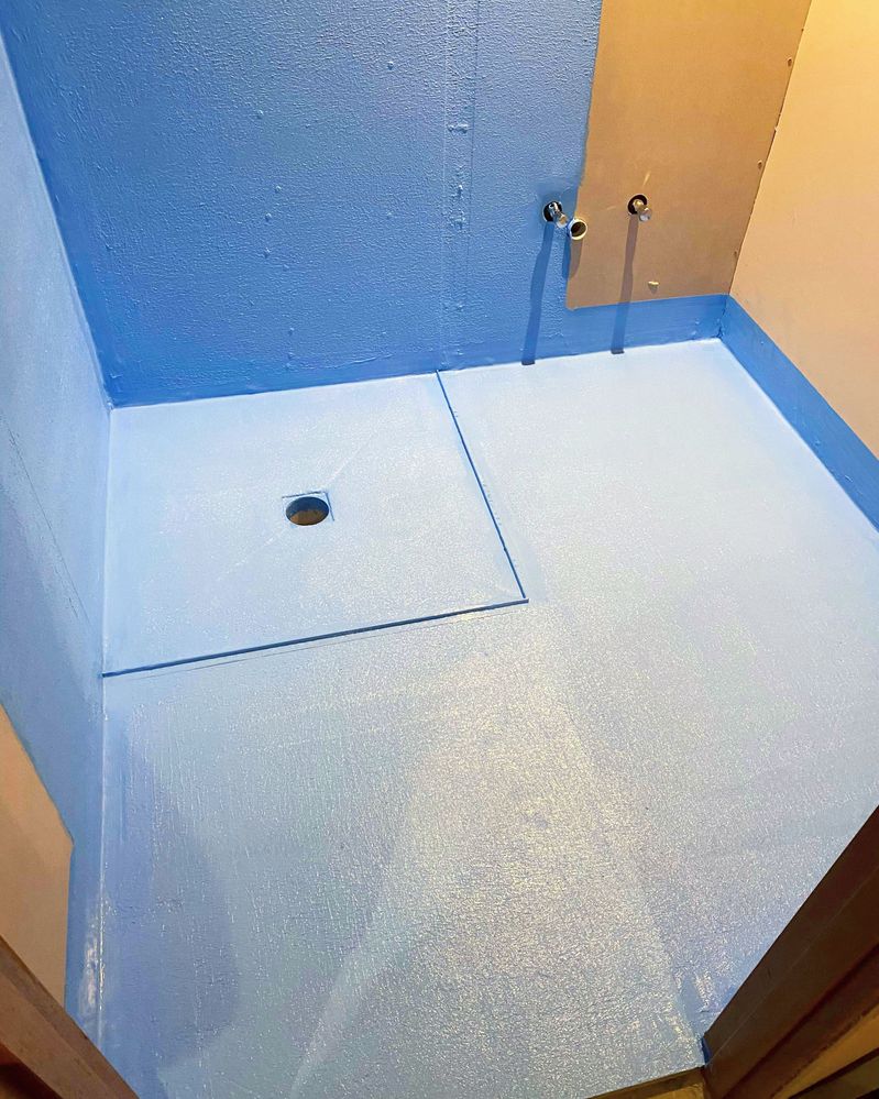 Under-tile waterproof membrane to floor and shower recess with waterstops.