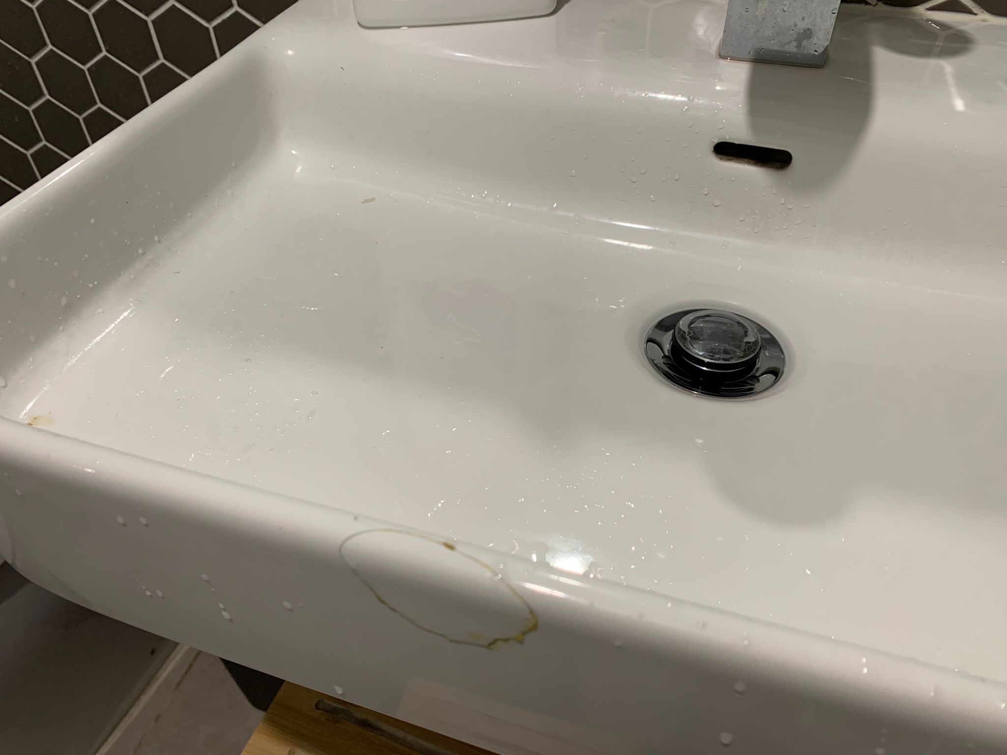 white paont in bathroom sink has chipped off