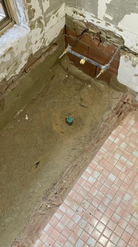 Previous bath location showing concrete slab and floor tiles to right
