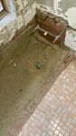 Previous bath location showing concrete slab and floor tiles to right