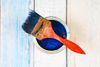 81877128-full-of-blue-paint-tin-and-paint-brush-on-it-isolated-on-wooden-background.jpg
