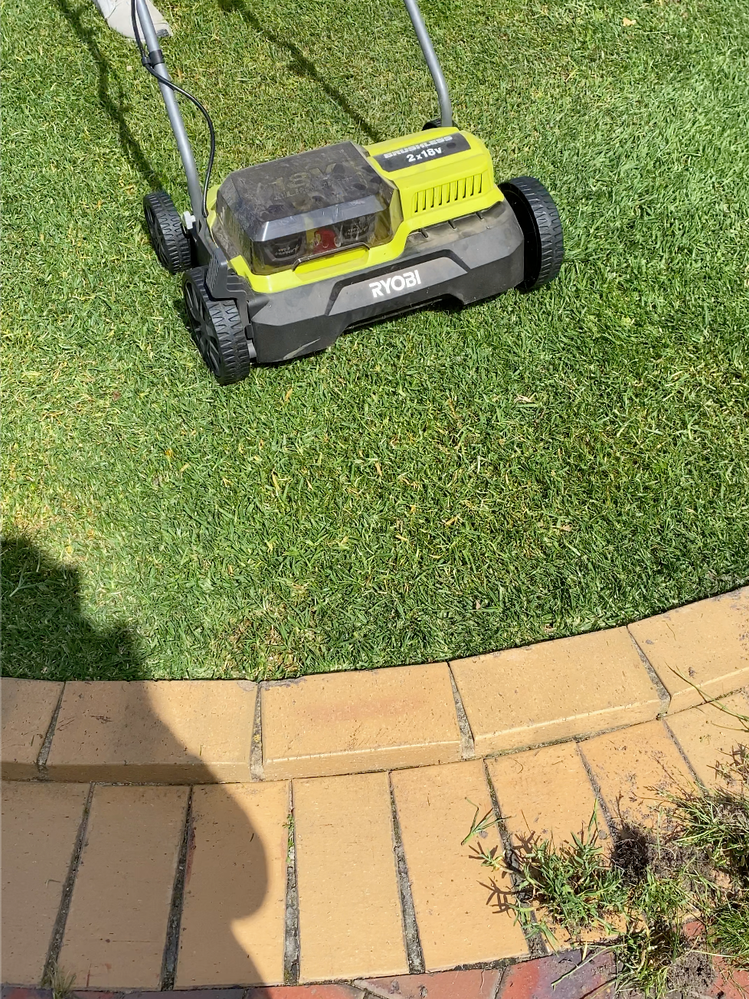 Running over the lawn using the power rake/dethatching attachment on the Ryobi scarifier.