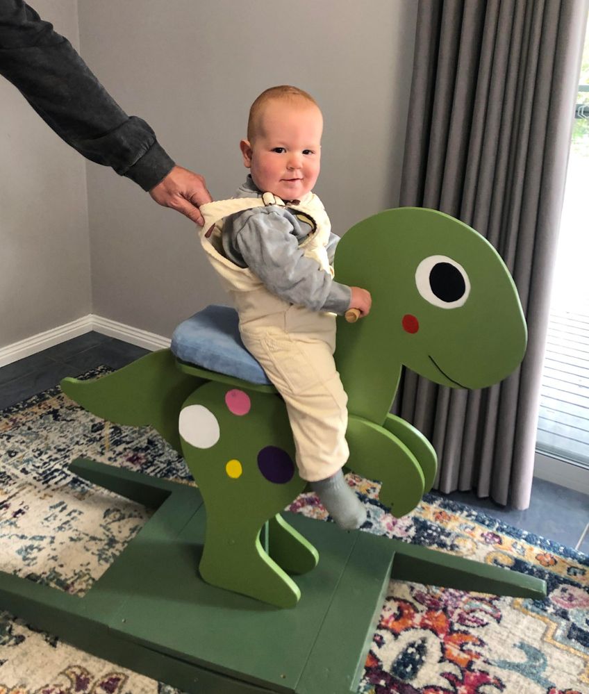 Birthday boy enjoying his new rocking dinosaur
