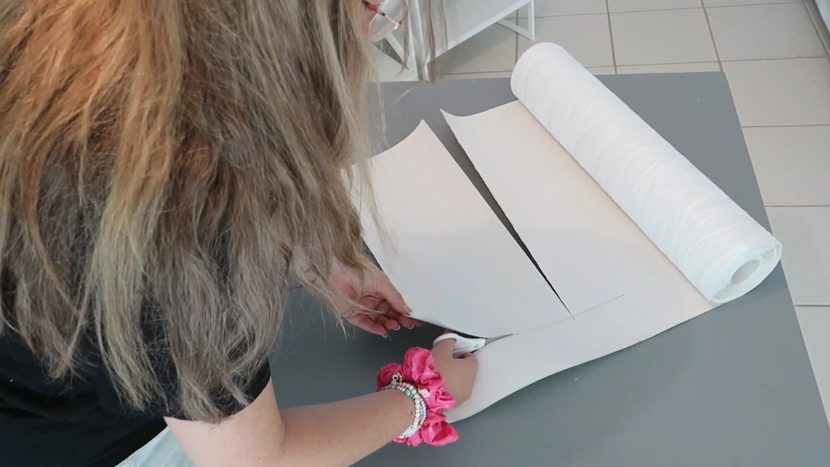 Measuring and cutting the wallpaper for the panels.