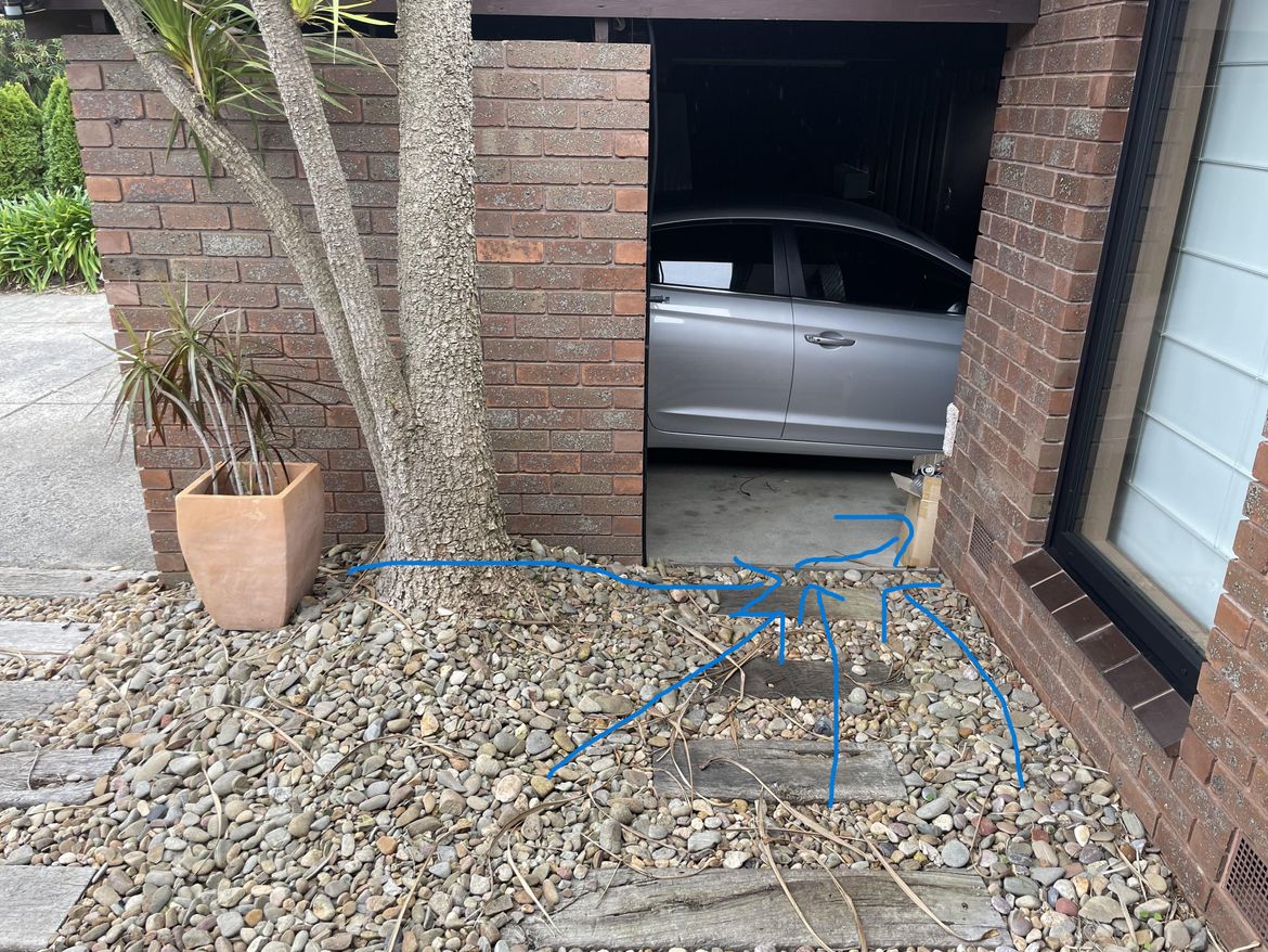 Blue arrows show flow of water into the garage during rain