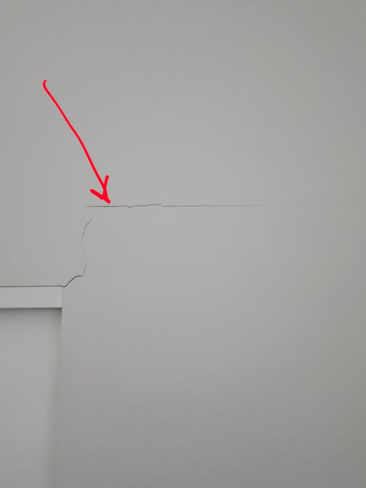 Crack radiating from bathroom sliding door frame, on the bedroom side